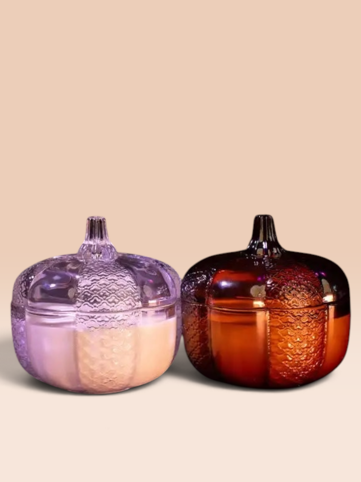 Grandeur Le Luxe amber and clear glass pumpkin storage jars with textured embossed details on a dark surface.